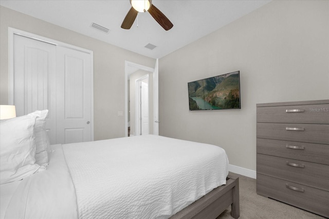 carpeted bedroom featuring ceiling fan and a closet