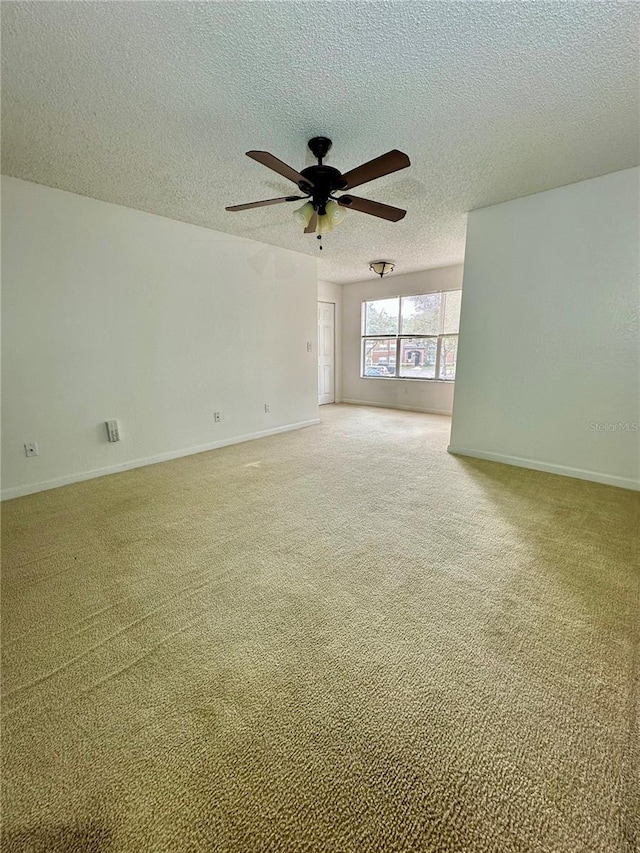 carpeted spare room with ceiling fan and a textured ceiling