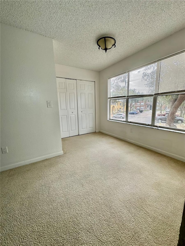 unfurnished bedroom with a closet, carpet floors, and a textured ceiling