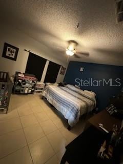 bedroom with ceiling fan and a textured ceiling