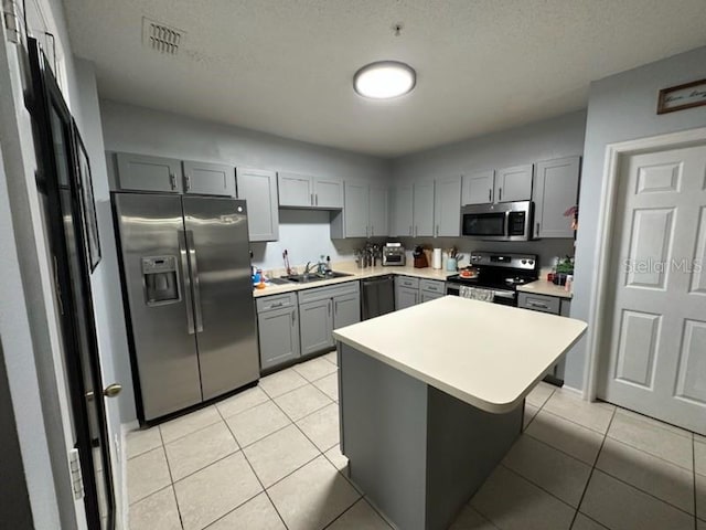 kitchen featuring gray cabinetry, sink, black appliances, light tile patterned flooring, and a textured ceiling