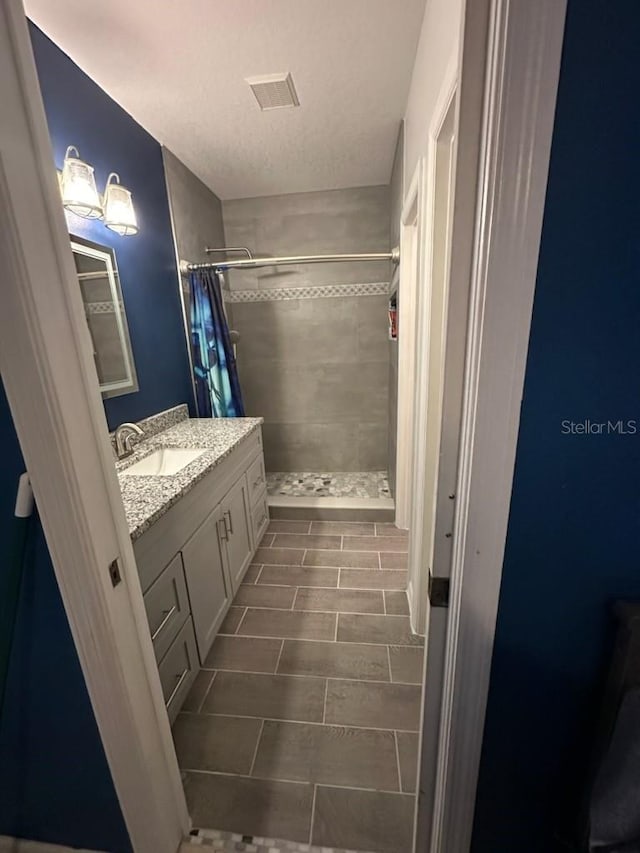 bathroom featuring vanity, walk in shower, and tile patterned flooring