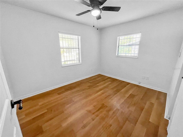 spare room featuring wood-type flooring, plenty of natural light, and ceiling fan