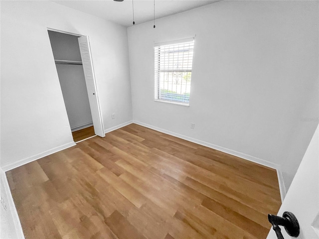 unfurnished bedroom with a closet and hardwood / wood-style flooring