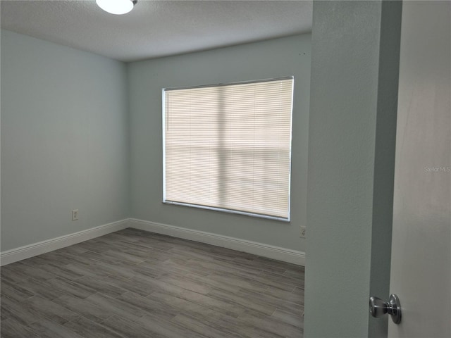 unfurnished room with a textured ceiling and light hardwood / wood-style floors