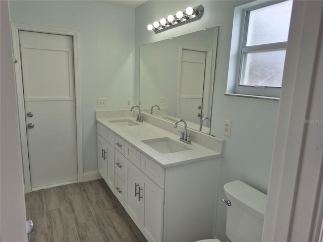 bathroom with hardwood / wood-style flooring, vanity, and toilet