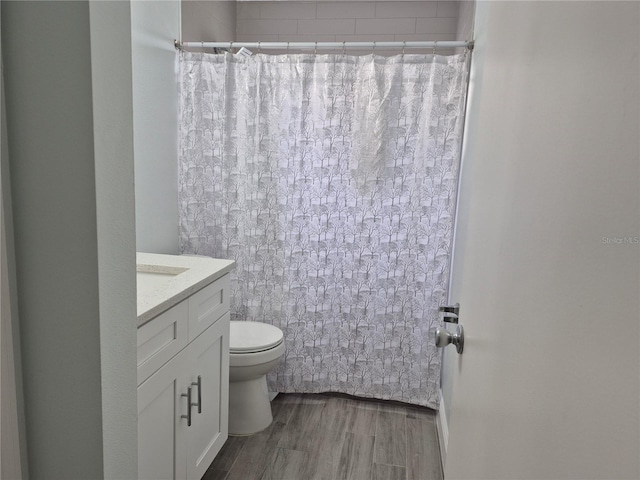 bathroom with wood-type flooring, toilet, vanity, and a shower with shower curtain