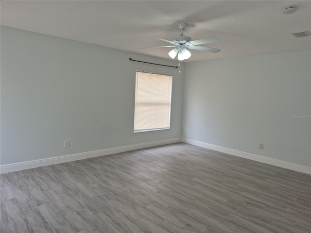 spare room with ceiling fan, a textured ceiling, and light hardwood / wood-style flooring