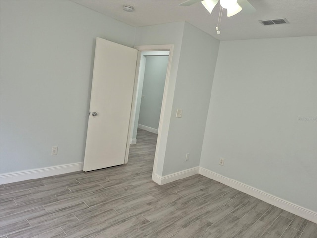 empty room with light hardwood / wood-style floors and ceiling fan