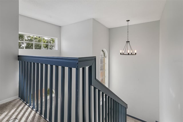 stairs featuring an inviting chandelier and carpet floors