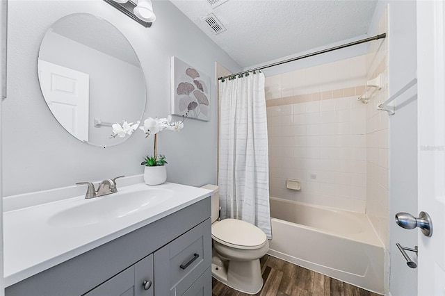 full bathroom featuring shower / bath combo, hardwood / wood-style flooring, a textured ceiling, toilet, and vanity