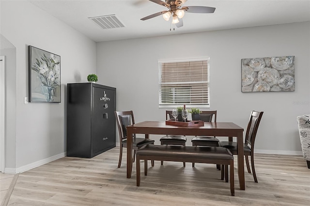 dining area with light wood-type flooring and ceiling fan