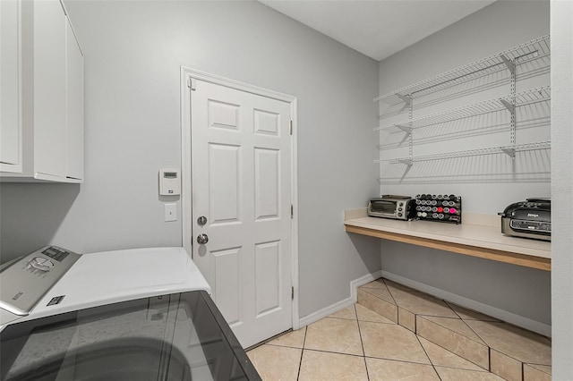 washroom with cabinets, light tile patterned floors, and washer / dryer