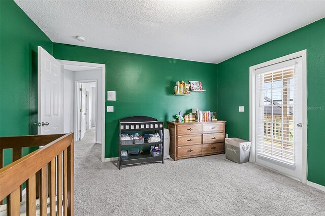 bedroom featuring light colored carpet and a textured ceiling