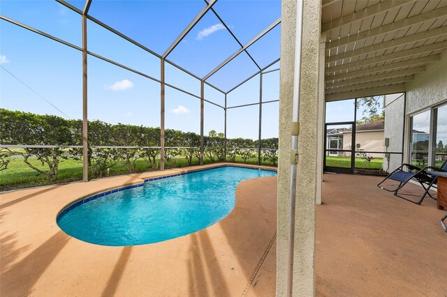 view of swimming pool featuring a lanai and a patio