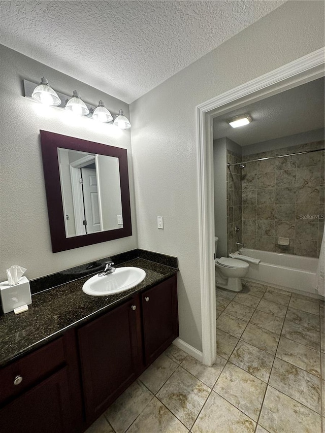 full bathroom featuring vanity, a textured ceiling, toilet, and tiled shower / bath