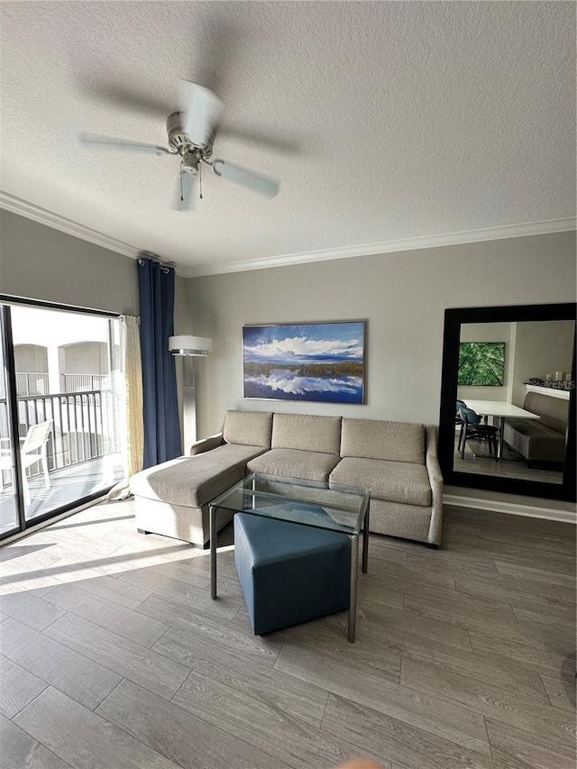 living room with ceiling fan, crown molding, wood-type flooring, and a textured ceiling