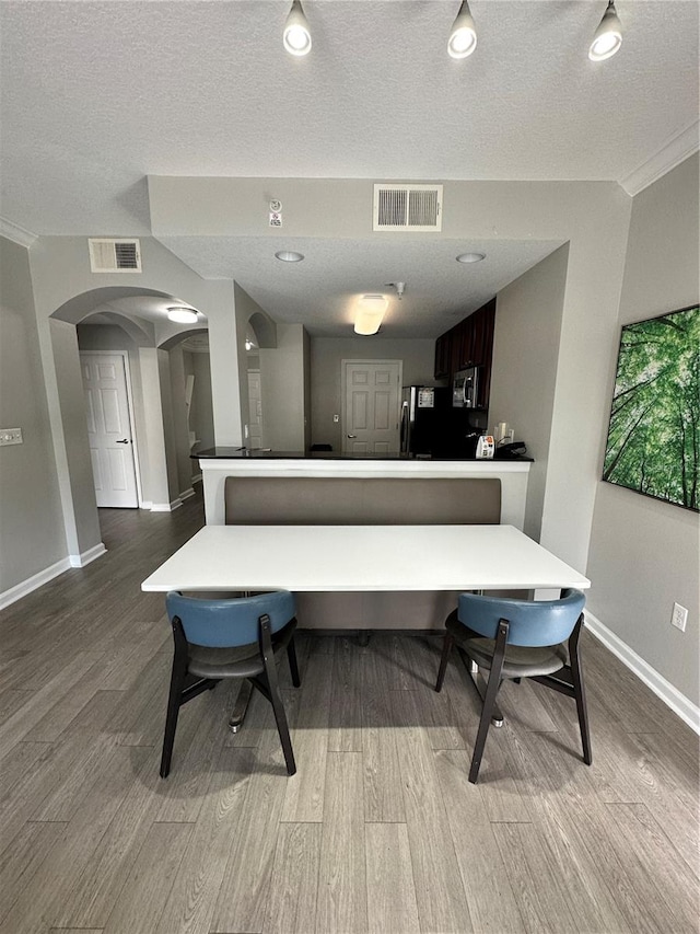 miscellaneous room with hardwood / wood-style floors, a textured ceiling, and crown molding