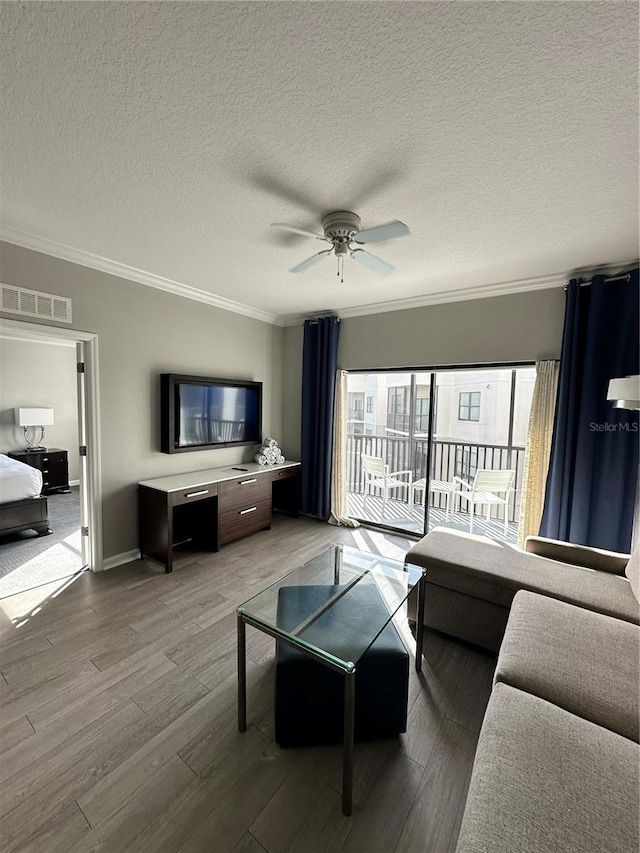 living room featuring ceiling fan, hardwood / wood-style floors, and a textured ceiling