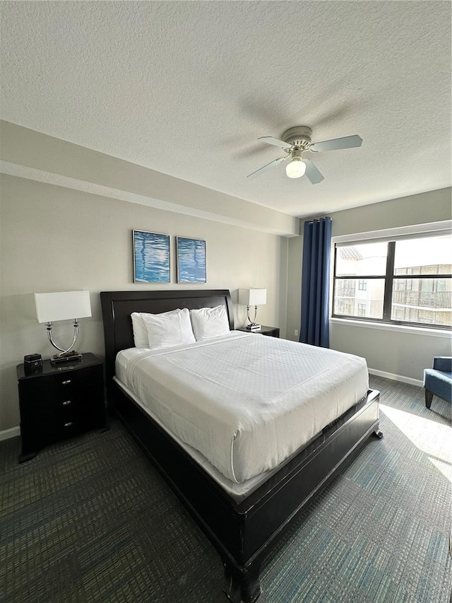 carpeted bedroom featuring ceiling fan and a textured ceiling