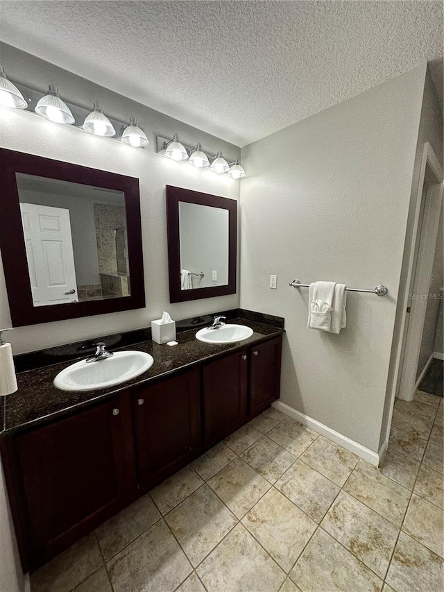 bathroom featuring tile patterned flooring, vanity, and a textured ceiling