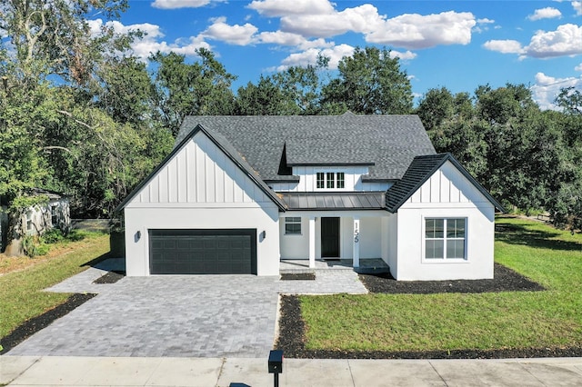 modern farmhouse style home with a garage and a front lawn