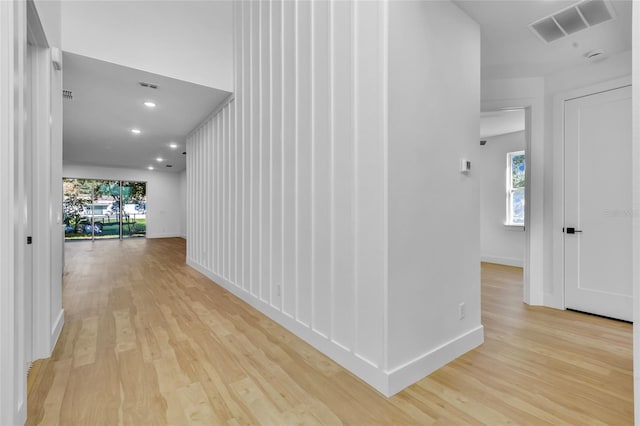 hall featuring plenty of natural light and light hardwood / wood-style flooring