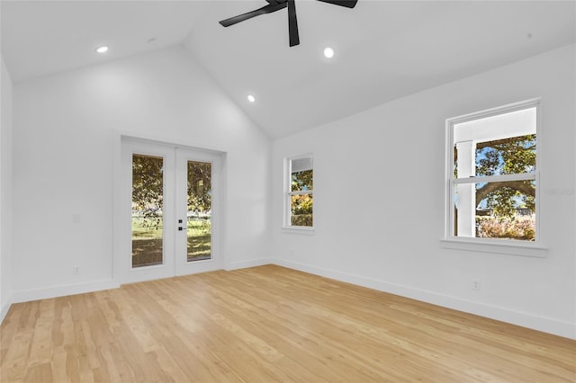 empty room featuring french doors, light hardwood / wood-style floors, high vaulted ceiling, and ceiling fan