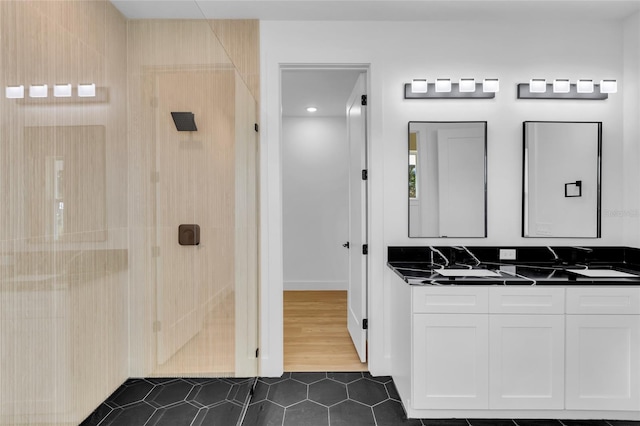 bathroom featuring tile patterned flooring, a shower, and vanity