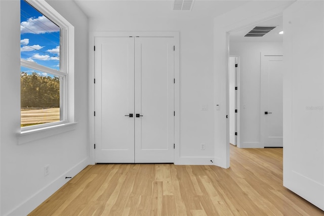 unfurnished bedroom with a closet and light hardwood / wood-style flooring