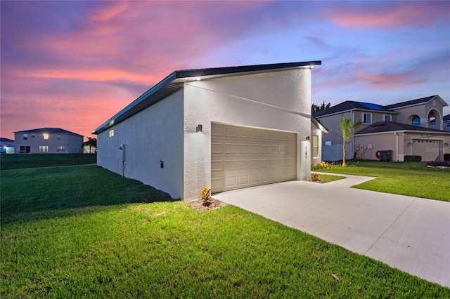 property exterior at dusk featuring a garage and a yard