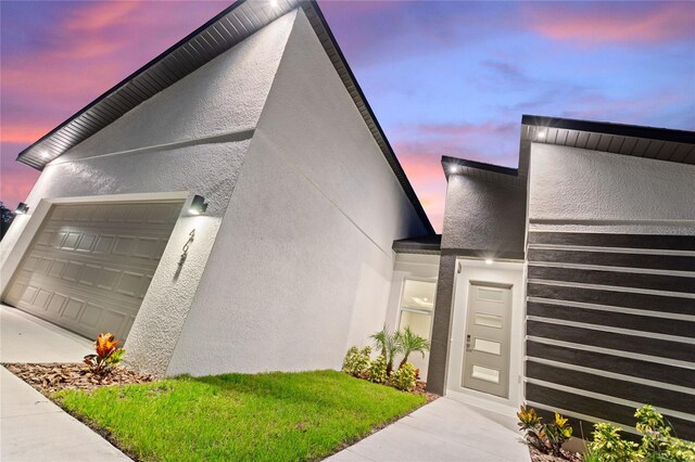 exterior entry at dusk with a garage