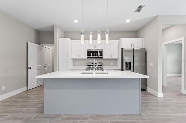 kitchen featuring white cabinetry, sink, a center island with sink, and stainless steel appliances