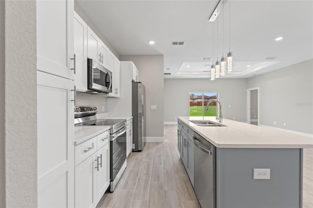 1877 Snapper Dr, Kissimmee, FL 34759 - kitchen with appliances with stainless steel finishes, a sink, light countertops, a center island with sink, and white cabinetry