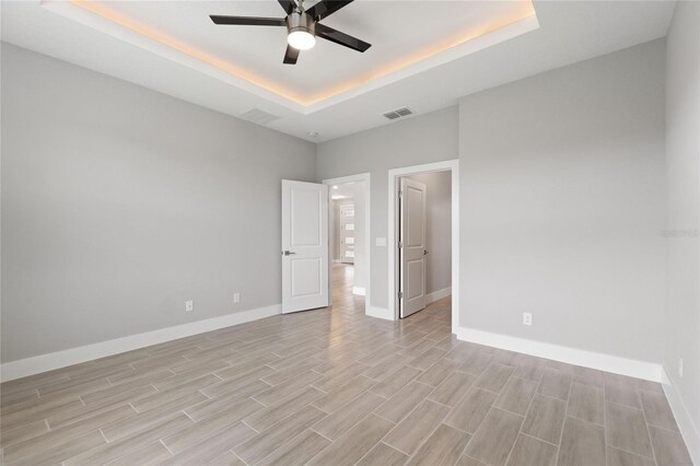1877 Snapper Dr, Kissimmee, FL 34759 - unfurnished room with a tray ceiling, a ceiling fan, light wood-style floors, and baseboards
