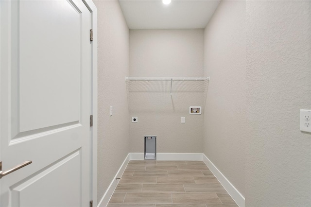 1877 Snapper Dr, Kissimmee, FL 34759 - laundry room with baseboards, electric dryer hookup, wood tiled floors, hookup for a washing machine, and a textured wall