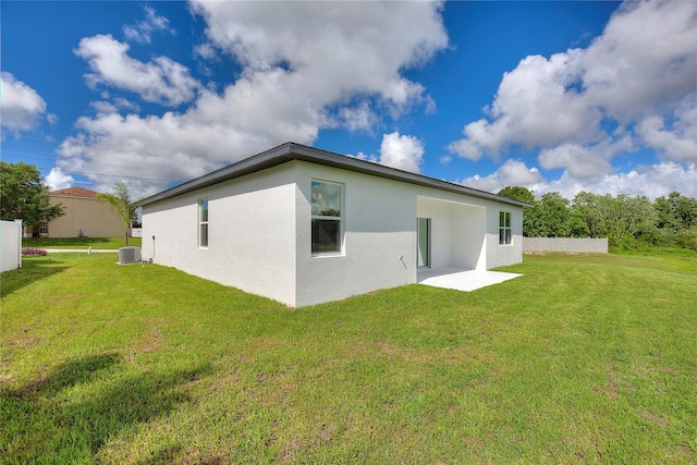 back of property with central air condition unit and a yard