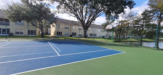 view of tennis court featuring a water view and basketball court