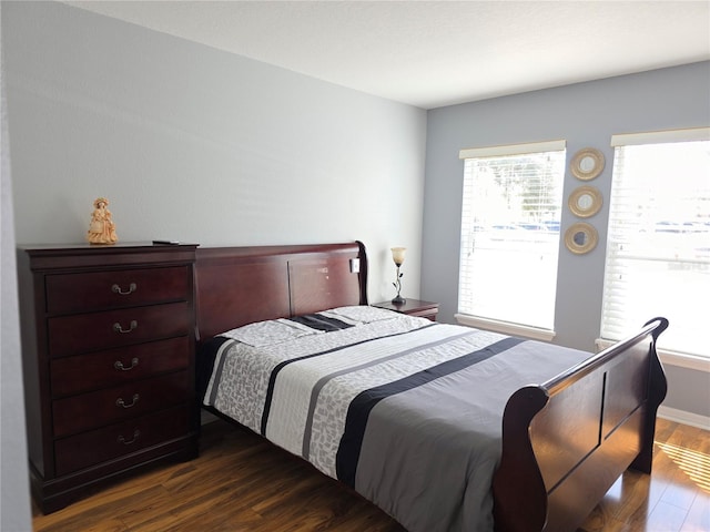 bedroom with dark hardwood / wood-style floors