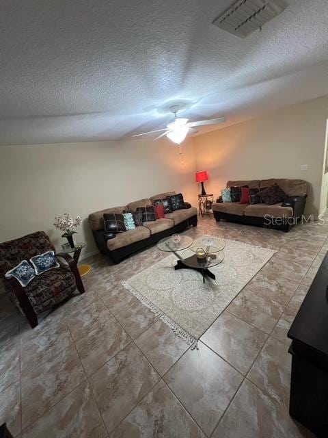 living room with a textured ceiling and ceiling fan