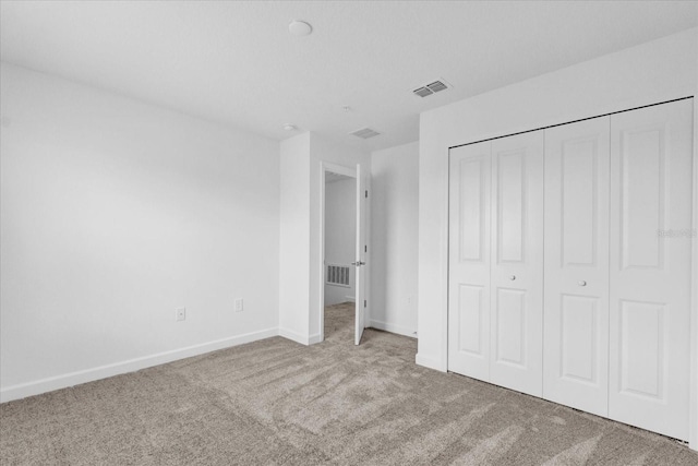 unfurnished bedroom featuring light carpet and a closet