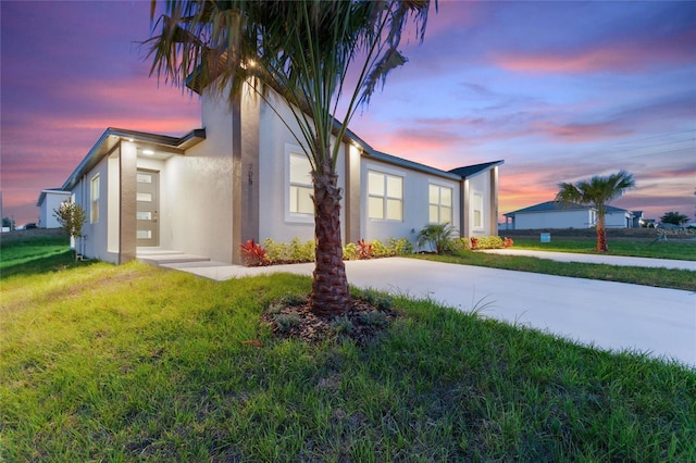 property exterior at dusk with a lawn