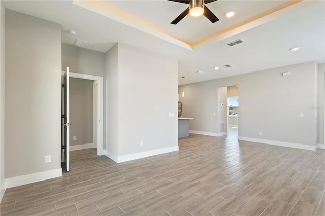 empty room with ceiling fan and light hardwood / wood-style flooring