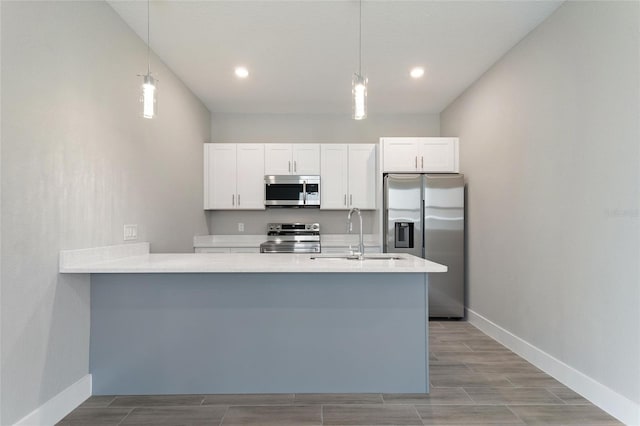 kitchen featuring white cabinetry, sink, pendant lighting, and appliances with stainless steel finishes