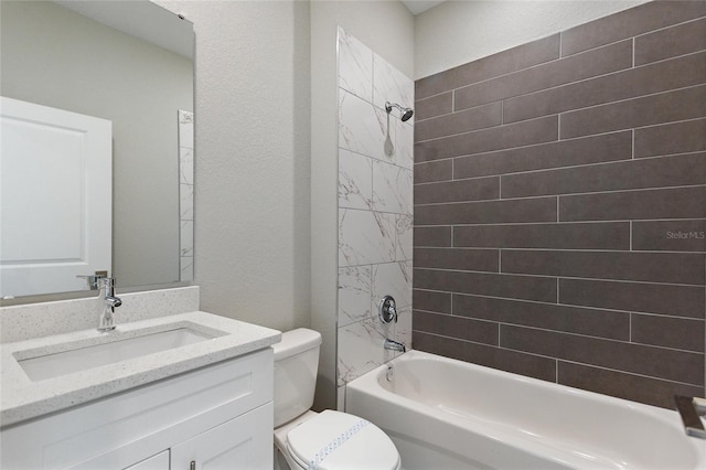 full bathroom featuring tiled shower / bath, toilet, and vanity