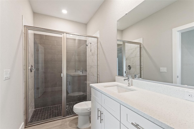 bathroom with toilet, vanity, hardwood / wood-style flooring, and walk in shower