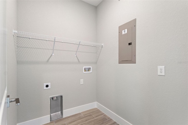 washroom with electric panel, washer hookup, hookup for an electric dryer, and light wood-type flooring