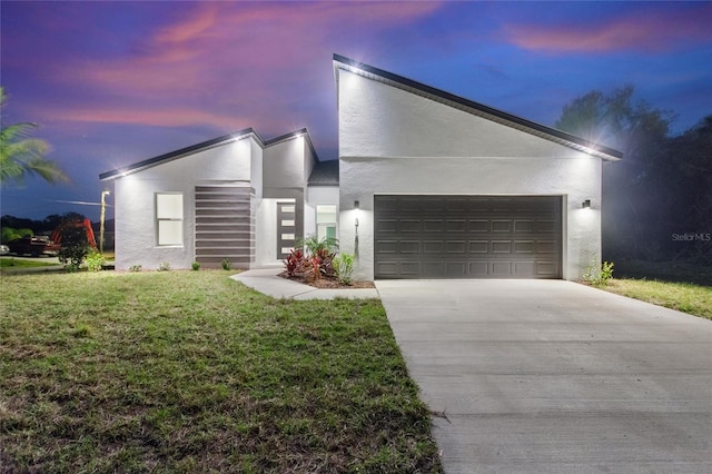 modern home featuring a garage and a yard