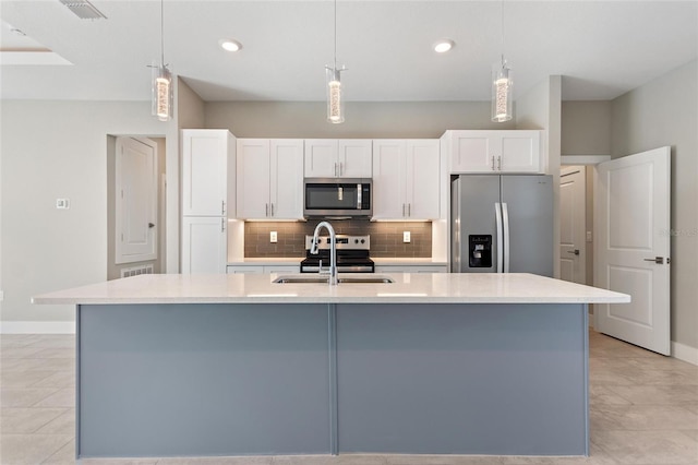 kitchen with white cabinets, an island with sink, and stainless steel appliances