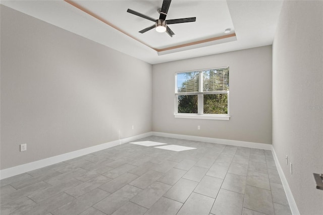 unfurnished room featuring ceiling fan and a tray ceiling